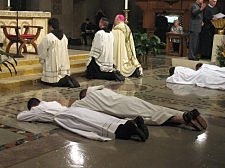 Dat. Q Tran, CSP (far left), and three other ordinands lie prostrate as the Liturgy of the Saints is prayed during his Mass of ordination to the transitional diaconate.