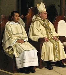 Dat Q. Tran, CSP (left), sits beside Bishop Francisco Gonzalez Valer, SF.