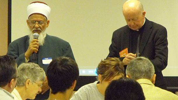 Imam Sharif Sahibzada (left) and Father John Geaney; CSP; director of the Catholic Information Center in Grand Rapids; Mich.; lead a moment of prayer during an interfaith event held at the center to combat anti-Muslim sentiment.