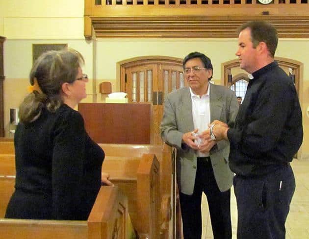 Father Thomas Gibbons, CSP (right), greets members of the congregation before the 6 p.m. Sunday evening Mass Oct. 13.