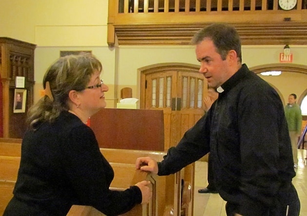 Father Thomas Gibbons, CSP, greets parishioners before the Sunday evening Mass at St. Peter's Church in Toronto.
