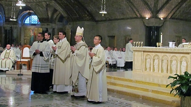 Newly-ordained Deacon Jimmy Hsu, CSP (at right) assists with the offertory.