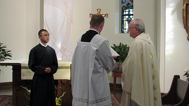 Jimmy Hsu, CSP (left), answers questions from Father Michael B. McGarry before makes his final promise with the Paulist Fathers Sept. 6 at St. Paul's College in Washington, D.C. Paulist student Michael Hennessy assists.