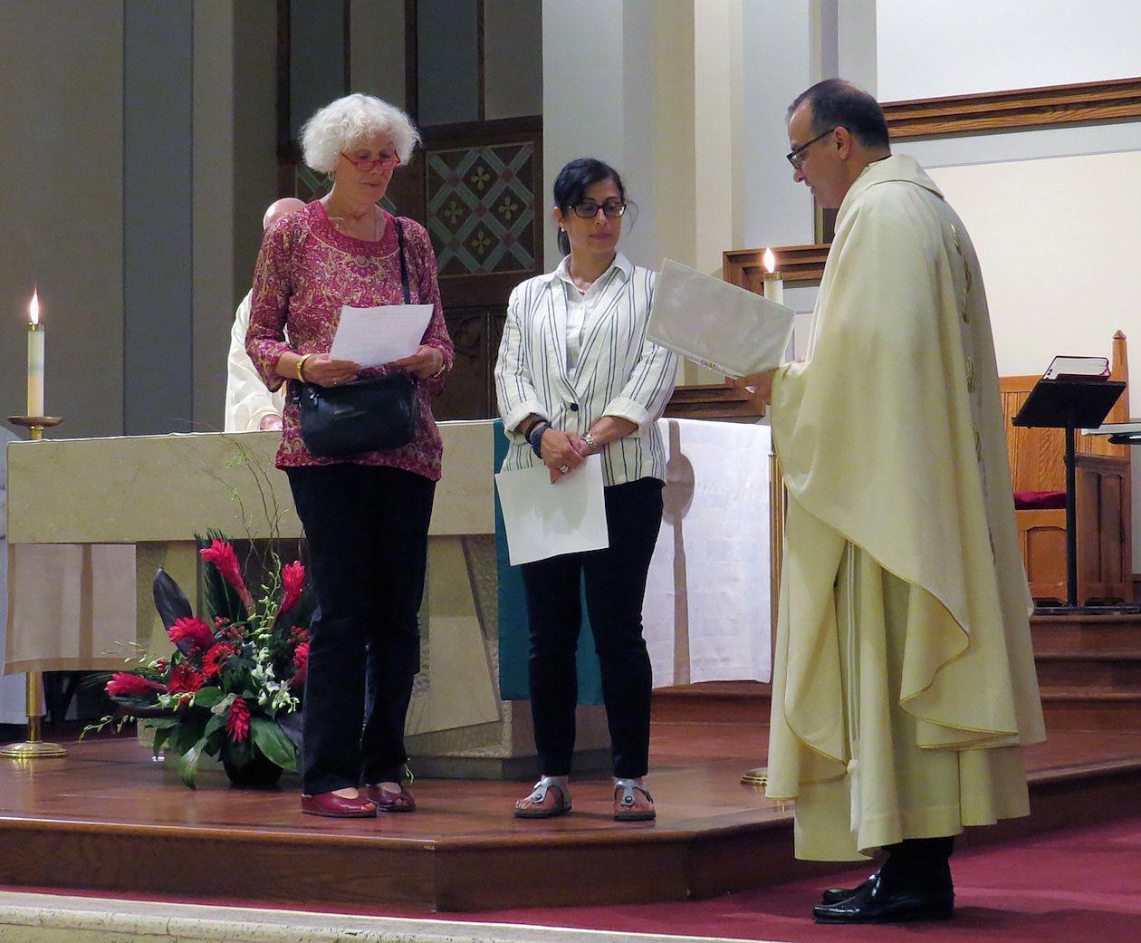 Inge Ali (left) and Angela Barbieri make their first promise as Paulist Associates received by Paulist President Father Eric Andrews.