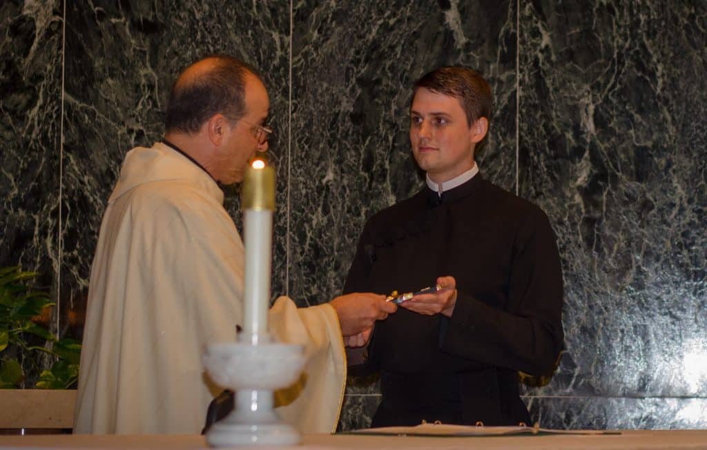 Paulist Fr. Eric Andrews, president of the Paulist Fathers, presents Evan Cummings with the Paulist Mission Cross