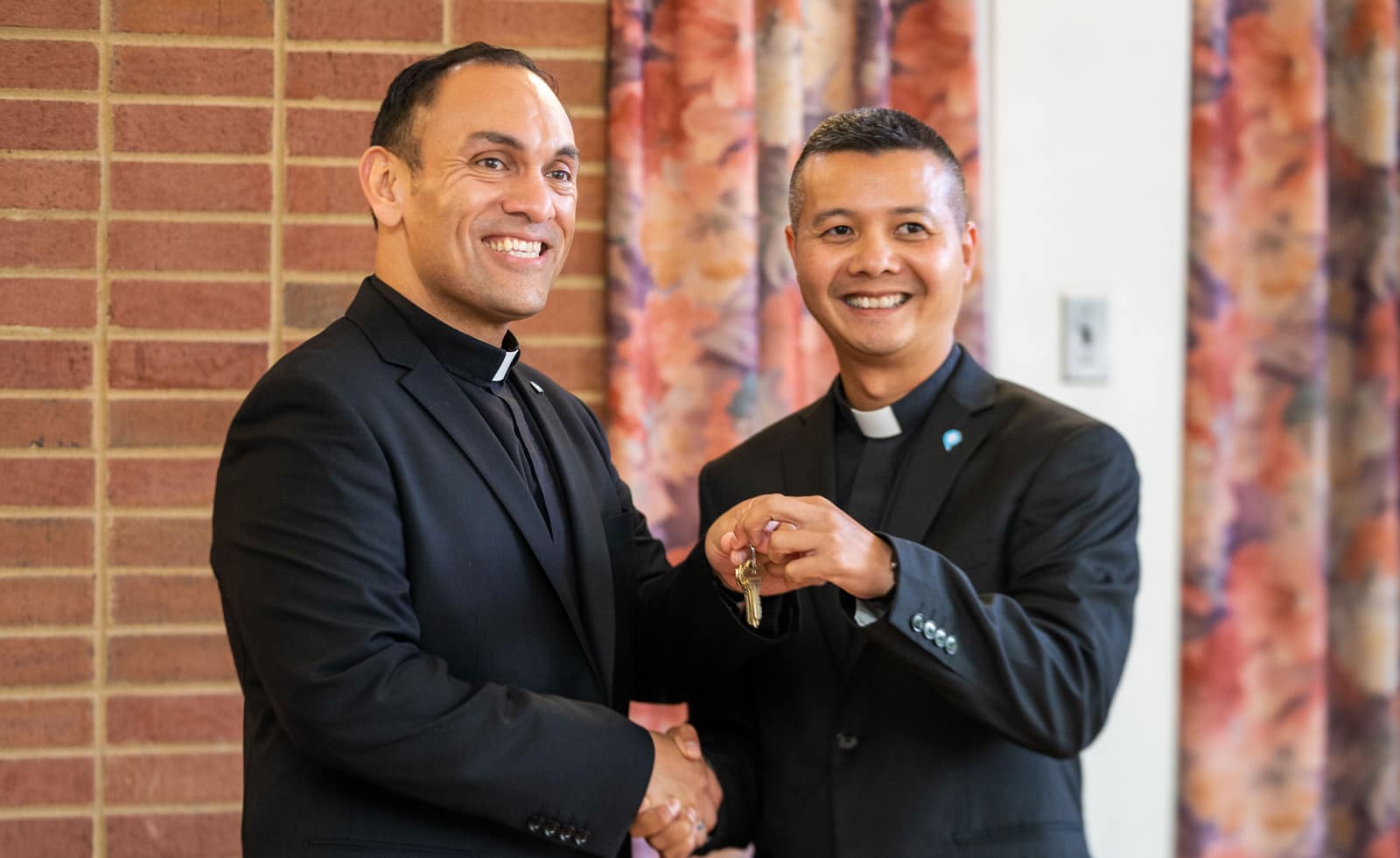 Handing off the keys to the cathedral: Paulist Fr. Dat Tran (right) will succeed the newly installed Paulist President Fr. René Constanza as pastor of the Cathedral of Saint Andrew in Grand Rapids, MI.